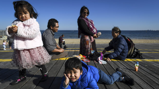 Ngun Dawi Zing, her mother Sui, husband Ngun T Lian and their three children Cung, 4, Zing, 2, and baby Van 5 months old cautiously out and about in St Kilda.