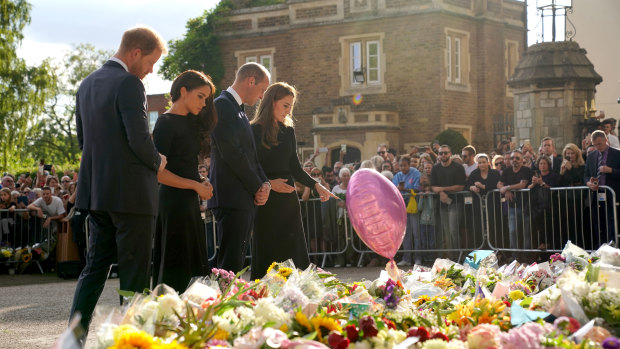 The two couples inspect flowers and cards left outside Windsor Castle.