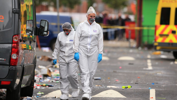 Forensic officers at the scene in the Moss Side area of Manchester, England, where several people have been injured after a shooting, early Sunday.