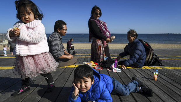 Ngun Dawi Zing, her mother Sui, husband Ngun T Lian and their three children Cung, 4, Zing, 2, and baby Van 5 months old cautiously out and about in St Kilda.