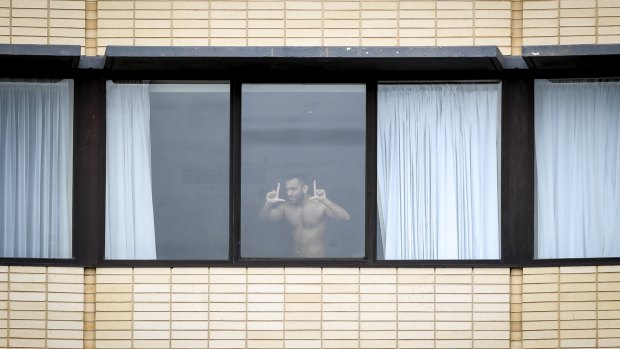 A man plays up to the camera while undergoing hotel quarantine at The Holiday Inn at Melbourne Airportin February.