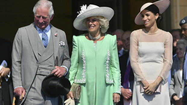 From left, Prince Charles, his wife Camilla, the Duchess of Cornwall, and Meghan, the new Duchess of Sussex attend a garden party at Buckingham Palace in London.