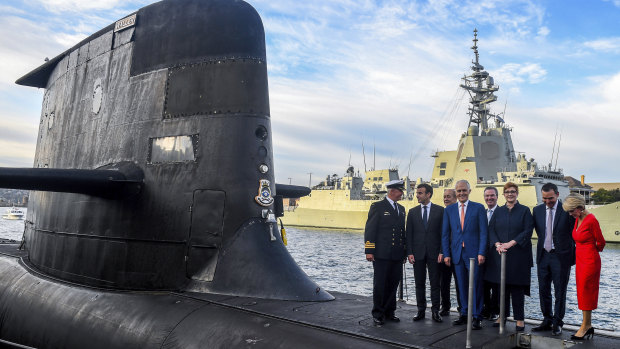 French President Emmanuel Macron, second left, and Prime Minister Malcolm Turnbull, centre, stand on the submarine HMAS Waller on Thursday.