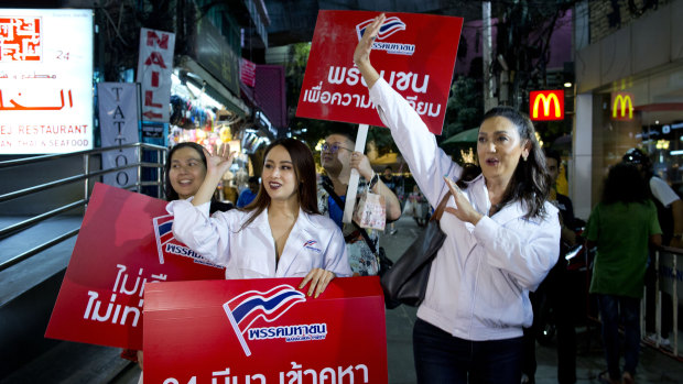 Pauline Ngarmpring, right, a transgender person and a prime ministerial candidate, and Namklenginarin, centre, a candidate for the parliament, greet people in Bangkok.