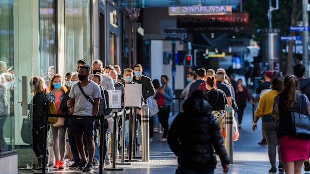 Shoppers wait in line to enter Zara in the Mall.
