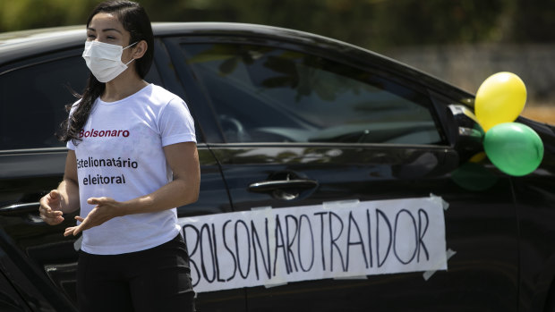 With a sign that reads in Portuguese “Bolsonaro Traitor,” a former supporter of Brazil’s President Jair Bolsonaro joins a protest in Rio on Sunday.