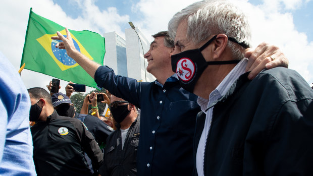Brazilian President Jair Bolsonaro and Secretary of Institutional Security and Brazilian Army General Augusto Heleno wave to supporters.