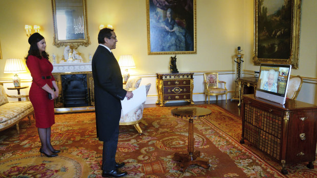 The Queen appears on a screen, right, from Windsor Castle during a virtual audience to receive the High Commissioner of Trinidad and Tobago, Vishnu Dhanpaul and his wife at Buckingham Palace, London, last week.