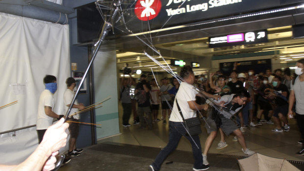 Men armed with metal rods and wooden poles attack commuters on July 21, 2019.