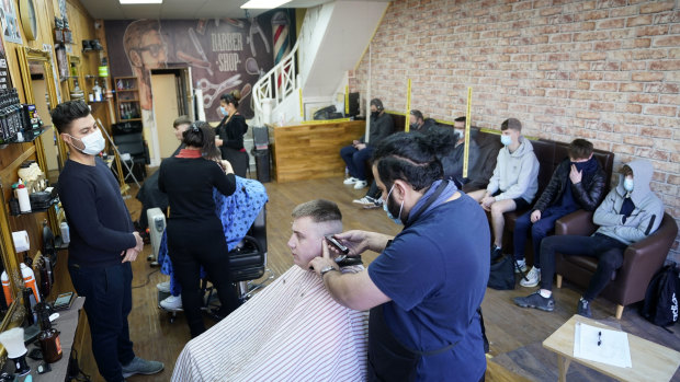 Customers have their hair cut at the Unique Traditional barber’s in Whitley Bay, England on Monday.