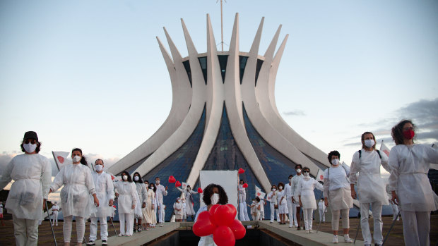 A person holds red balloons during a performance by artists from the Federal District in honour of the victims of coronavirus at Brasília's Cathedral in Brazil.