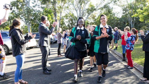 Staff at Brisbane's Bray Park State High School form a guard of honour to welcome back Year 12 students.
