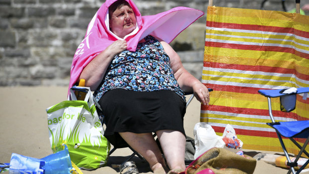 A woman enjoys the sun at Barry Island, south Wales, in late June.