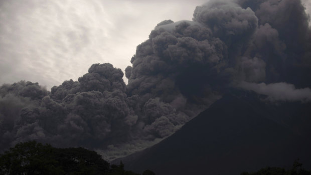 Volcan de Fuego, or Volcano of Fire, blows outs a thick cloud of ash.