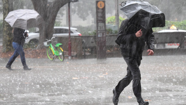 Pedestrians brave the rain in Sydney's CBD on Monday.