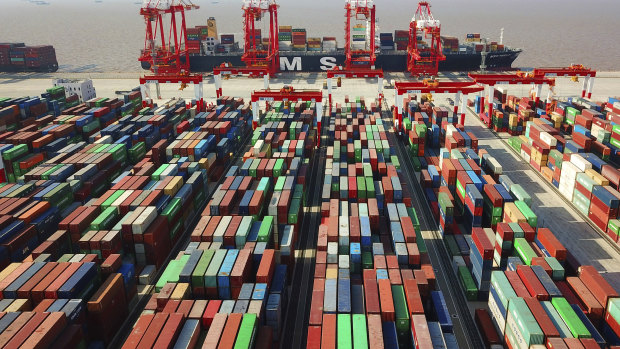 A trade war is dividing the US and China. A cargo ship is docked at the Yangshan container port in Shanghai, China. 