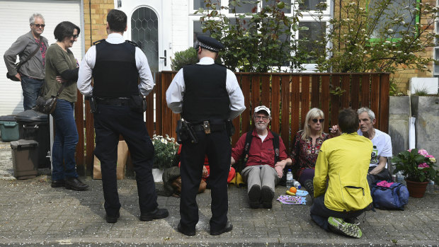 Police officers talk with climate activists  glued together outside UK Labour Party leader Jeremy Corbyn's house in north London on Wednesday.