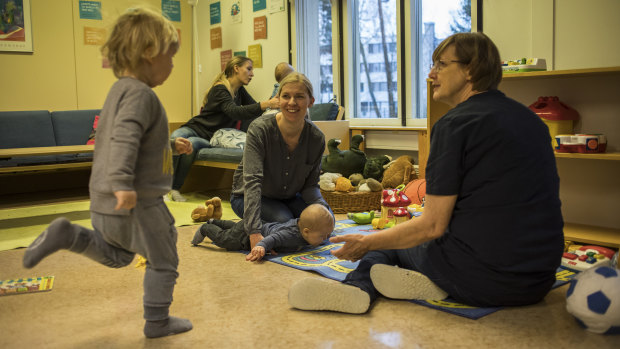 Parents and children at a day care centre. Finland has a good and cheap universal health care system, free university education and affordable child care.