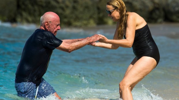 Take my hand: Hall helps Murdoch from the surf.