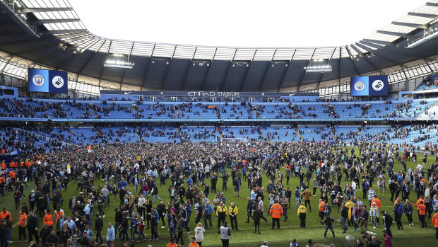Manchester City fans invade the pitch after their first home game since clinching the Premier League title.