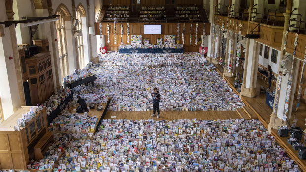 Captain Tom's grandson Benjie stands in the Great Hall of Bedford School where more than 125,000 birthday cards have been sent from around the world.
