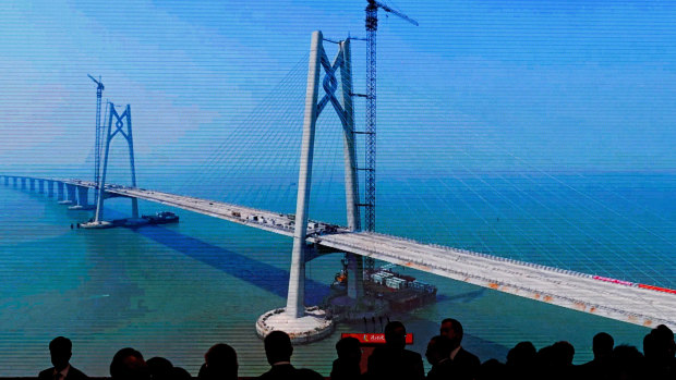 A projector screen shows the construction of the China-Zhuhai-Macau-Hong Kong Bridge ahead of the opening ceremony.