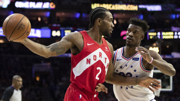 Toronto's Kawhi Leonard (left) holds the ball away from the 76ers' Jimmy Butler.