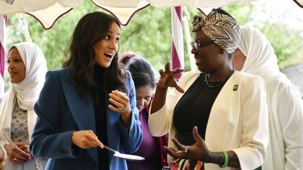 Meghan, the Duchess of Sussex, with one of the women behind a charity cookbook during a reception at Kensington Palace in September.