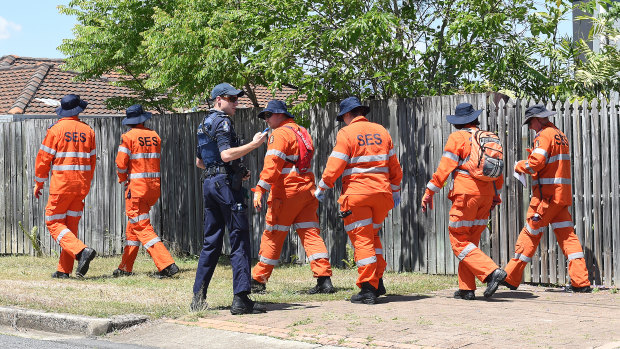 State Emergency Service crews search for clues after the mother-of-two's body was discovered in her Greenslopes home.