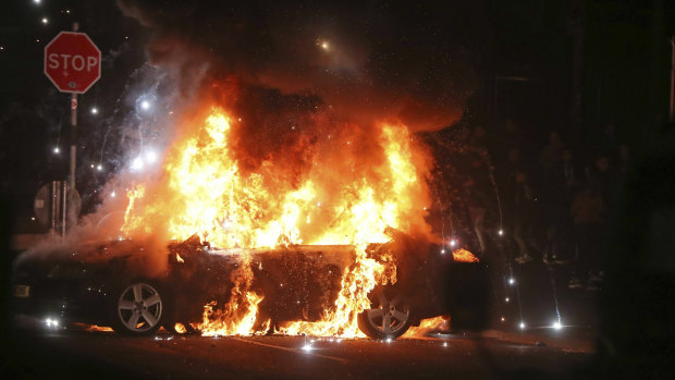 A car burns after petrol bombs were thrown at police in Creggan, Londonderry.