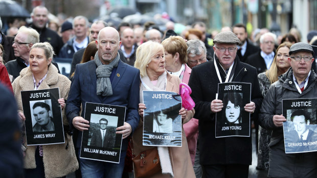 Families hold photographs of the victims of Bloody Sunday and march through the Bogside in Londonderry on Thursday.