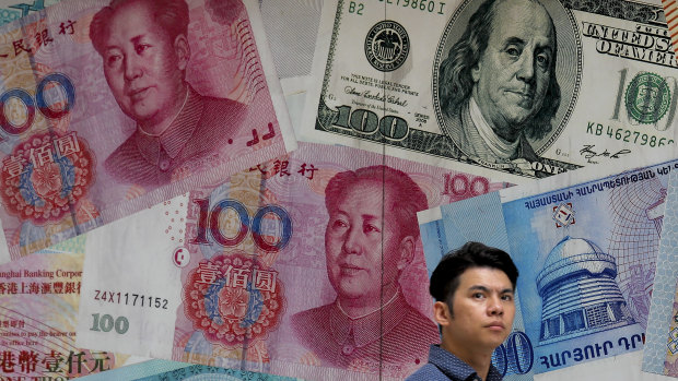 A man walks past a money exchange shop decorated with different banknotes in Hong Kong.