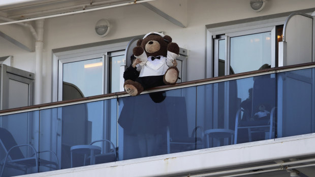 A woman holds a teddy bear on the balcony of the Diamond Princess cruise ship docked in Yokohama.