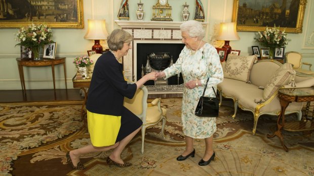 Theresa May kneels before the Queen at Buckingham Palace, where the monarch invited May in 2016 to become Prime Minister and form a new government. 