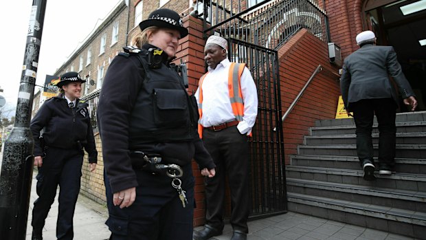 Police officers patrol the area outside Finsbury Park Mosque in London following the Christchurch mosque attacks, as worshipers begin to arrive for the Friday prayer service.