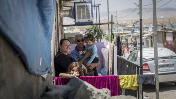 A family stands outside their home in the Domiz camp for Syrian refugees, near the town of Dohuk, northern Kurdistan, Iraq.