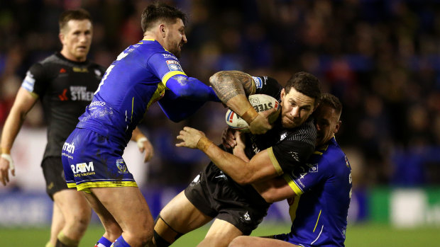 Williams is dragged down by Warrington's Gareth Widdop (left) and Ben Currie.