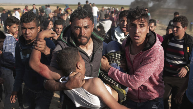 Palestinian protesters carry a wounded man who was shot by Israeli troops.