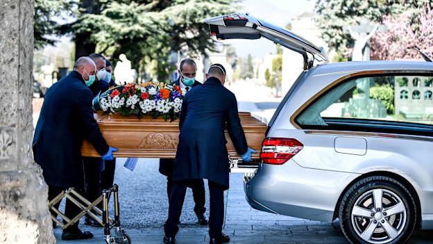 Undertakers carry a coffin out of a hearse at Bergamo's cemetery, northern Italy. 
