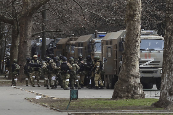 Russian army soldiers stand next to their trucks in Kherson, Ukraine in March.