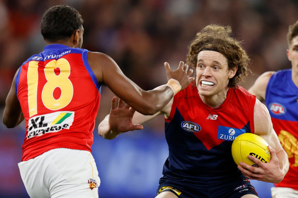 Demons forward Ben Brown is tackled by the Lions’ Keidean Coleman.