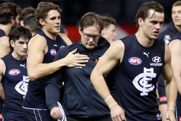 Charlie Curnow, left, consoles Carlton coach David Teague, centre, during round 23.  