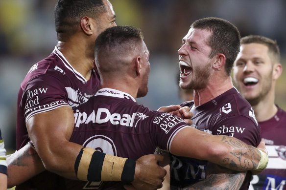 Cade Cust (right) celebrates a try with Manly teammates on Friday night.