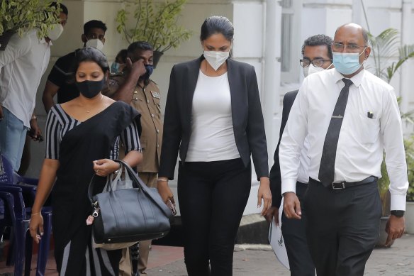 The reigning Mrs World Caroline Jurie, centre, leaves a police station in Colombo after being granted bail.