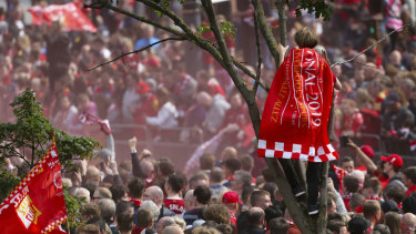 Fans get any spot they can to welcome the team.
