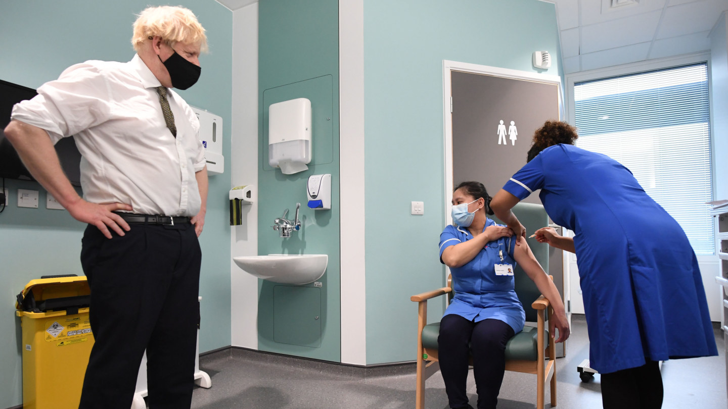 British Prime Minister Boris Johnson watches vaccination in progress at Chase Farm Hospital.