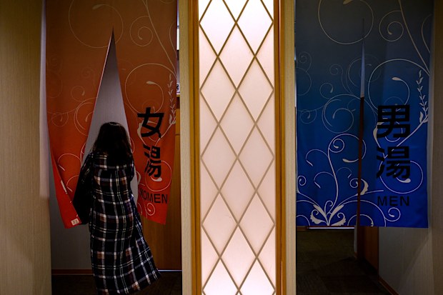 A woman enters a Japanese onsen in Yokohama, Kanagawa prefecture