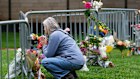 A visitor offers a tribute after leaving a bouquet of flowers at a makeshift memorial for victims of an attack in Boulder, Colorado.