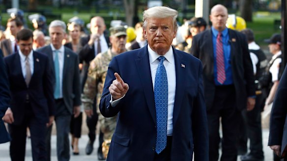 President Donald Trump returns to the White House with his security after visiting St John's Church, 200 metres away, on Monday.
