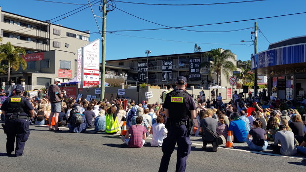 Protesters sit in silence for seven minutes to mark seven years of offshore detention for some of the refugees being kept in the  Kangaroo Point hotel.